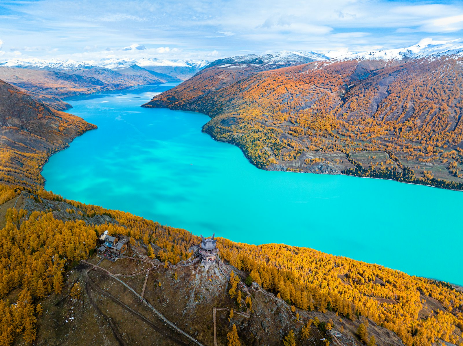 Kanas Lake in Xinjiang: turquoise water between mountainsides of golden autumn larch trees